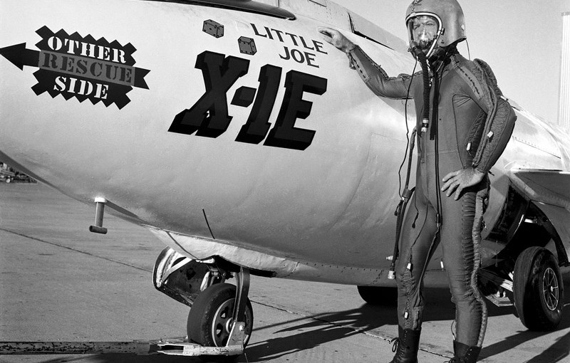Joe Walker in pressure suit with X-1E Description: Joe Walker in a pressure suit beside the X-1E at the NASA High-Speed Flight Station, Edwards, California. The dice and "Little Joe" are prominently displayed under the cockpit area. (Little Joe is a dice players slang term for two deuces.) Walker is shown in the photo wearing an early Air Force partial pressure suit. This protected the pilot if cockpit pressure was lost above 50,000 feet. Similar suits were used in such aircraft as B-47s, B-52s, F-104s, U-2s, and the X-2 and D-558-II research aircraft. Five years later, Walker reached 354,200 feet in the X-15. Similar artwork - reading "Little Joe the II" - was applied for the record flight. These cases are two of the few times that research aircraft carried such nose art. UID: SPD-NIX-E-3361